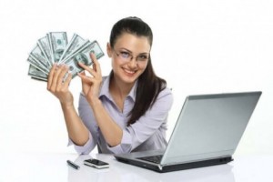 smiling-girl-with-cash-in-the-hand-and-laptop-cellphone-e1439317349934